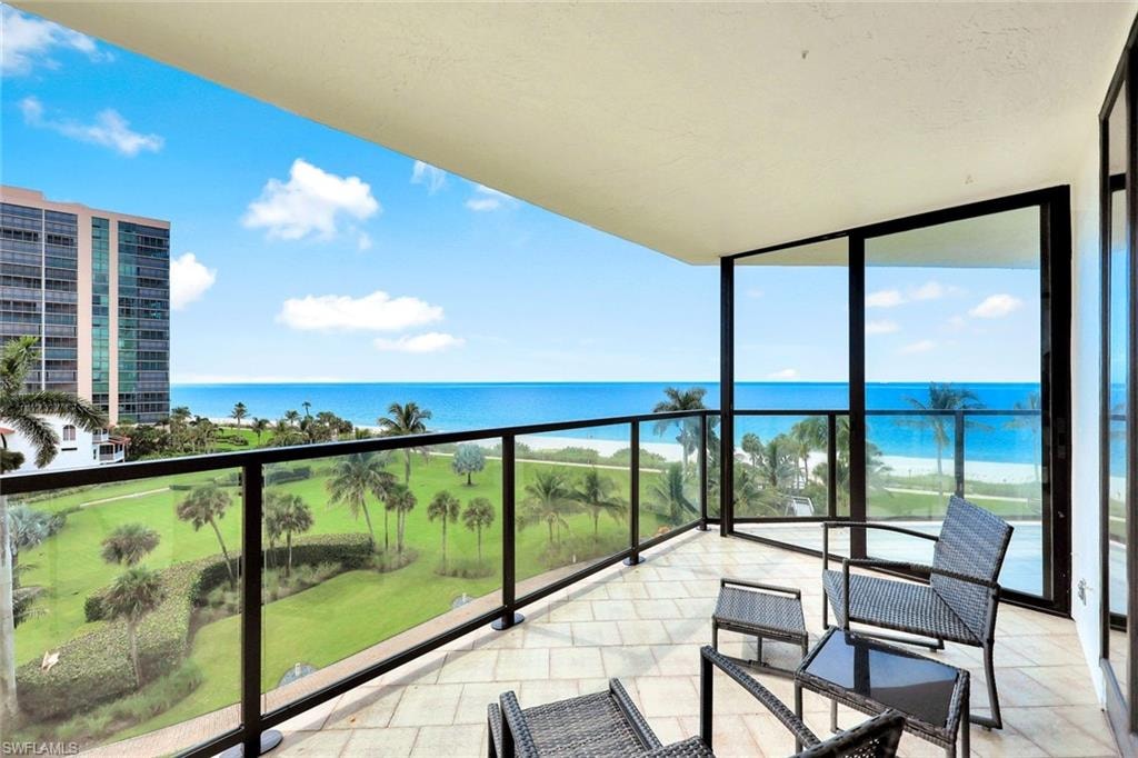Balcony featuring a sunroom and a water view