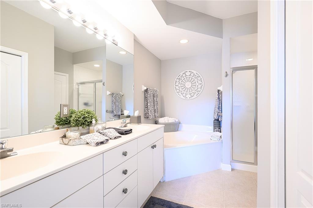 Bathroom featuring tile patterned flooring, independent shower and bath, and vanity