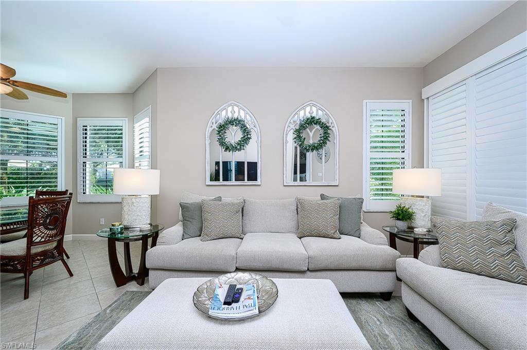 Living room featuring light tile patterned floors and ceiling fan