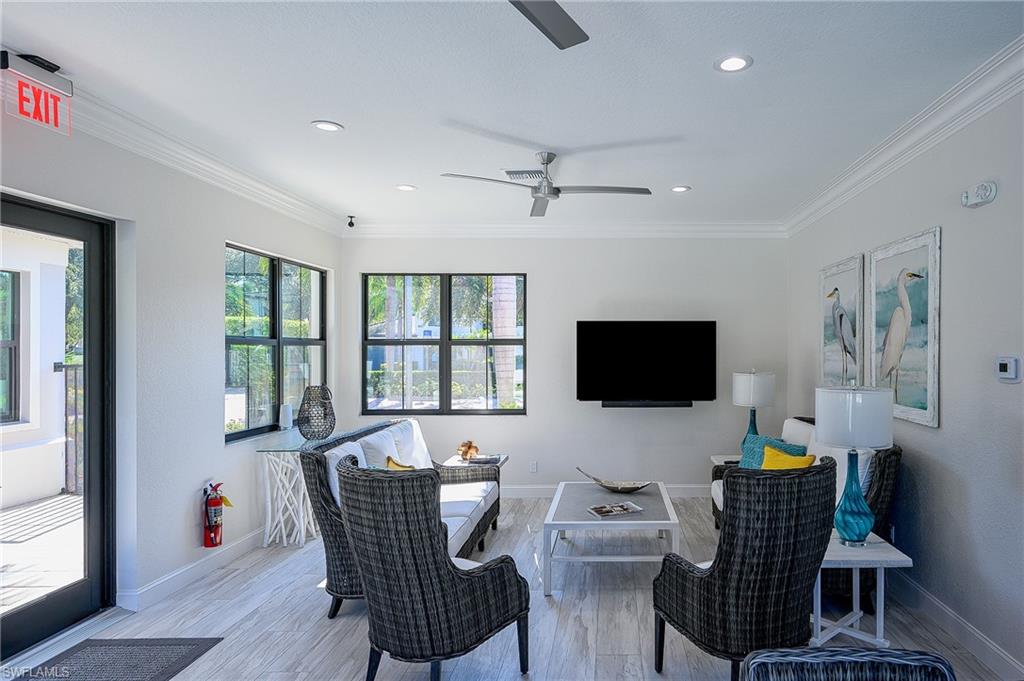 Living room featuring ceiling fan, light hardwood / wood-style flooring, and ornamental molding
