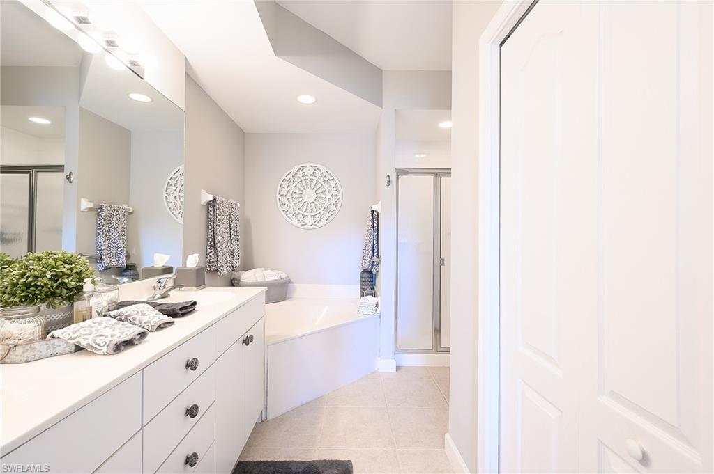 Bathroom featuring vanity, separate shower and tub, and tile patterned flooring