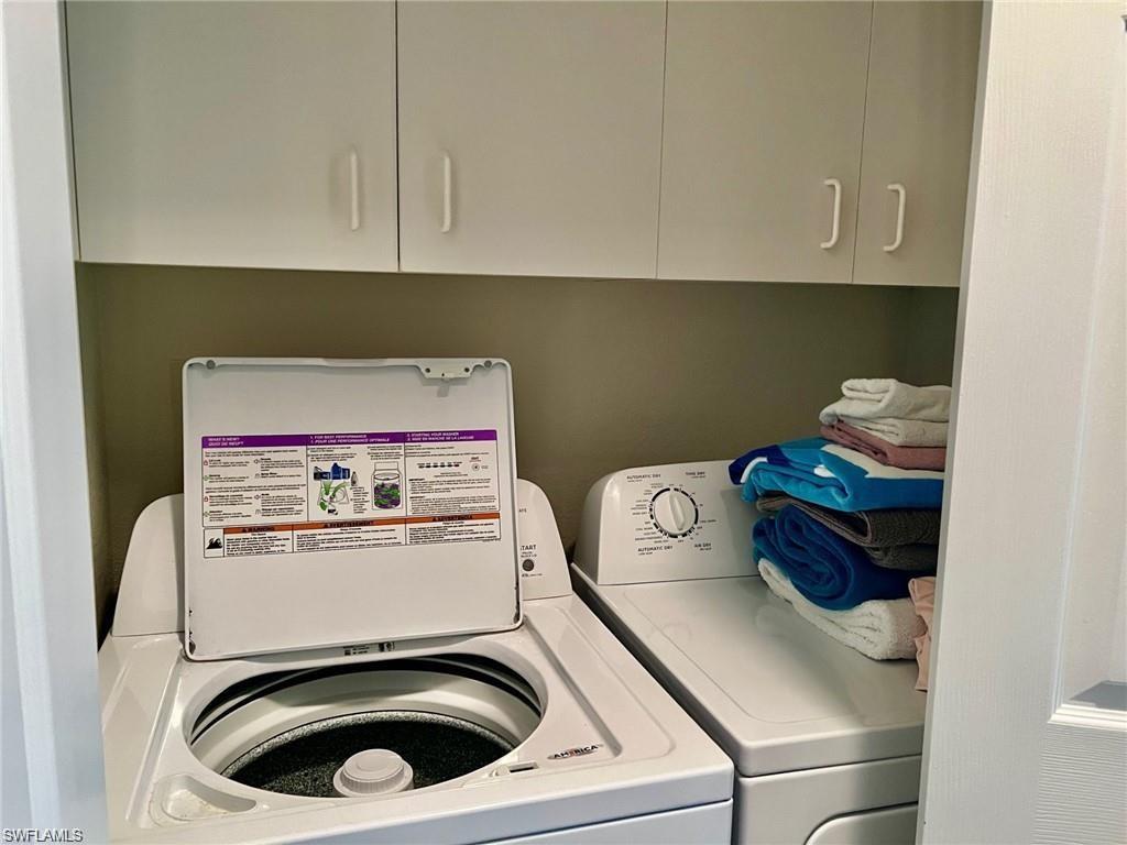 Washroom featuring separate washer and dryer and cabinet space