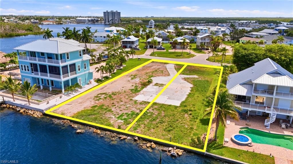 Waterfront lot featuring a partial concrete driveway and grass coverage- Virtually Edited Image