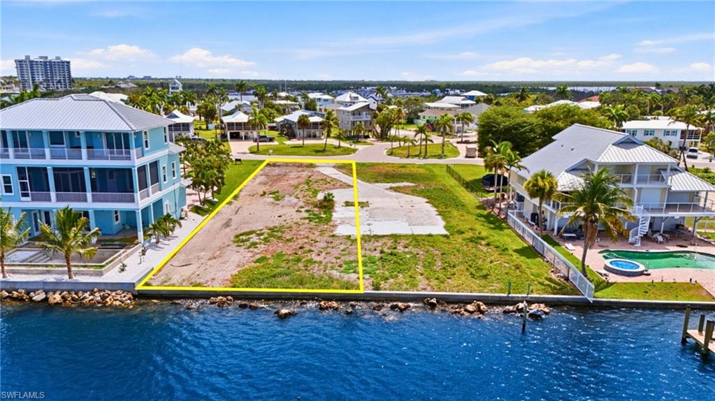 Waterfront lot featuring a partial concrete driveway and a rock seawall- Virtually Edited Image
