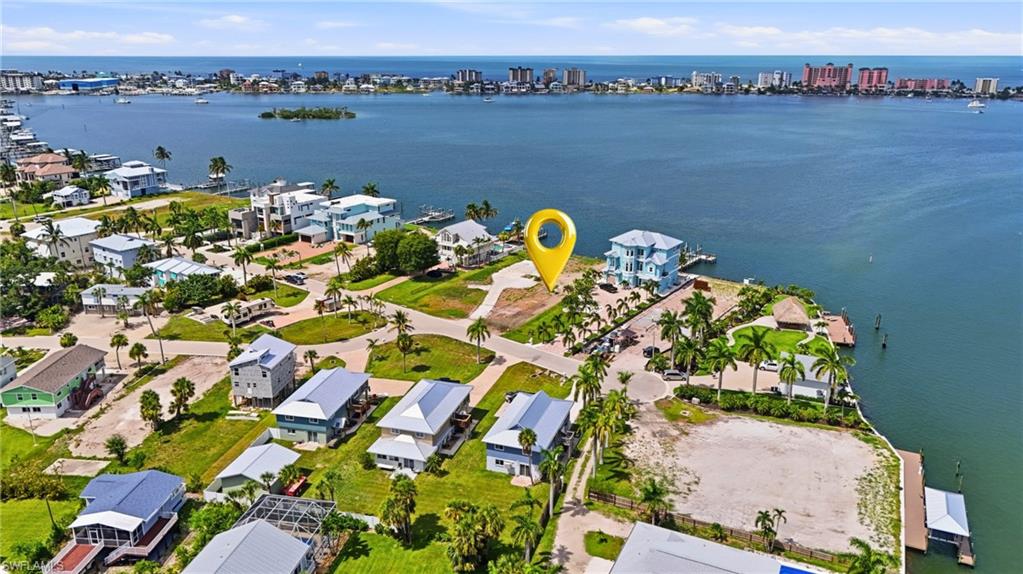 Waterfront parcel featuring a wide expanse of open water, adjacent residential properties, and a distant city skyline- Virtually Edited Image