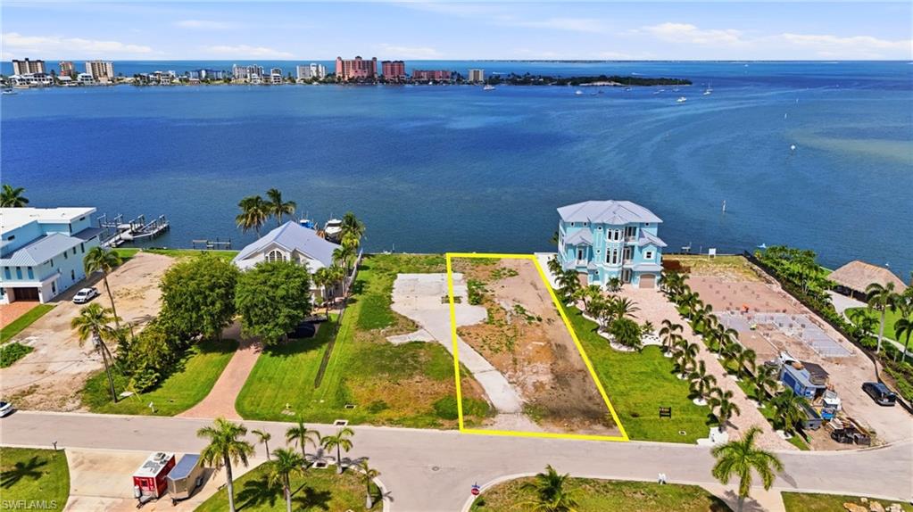 Waterfront lot with substantial water frontage, featuring an established concrete driveway and ample space for custom construction- Virtually Edited Image