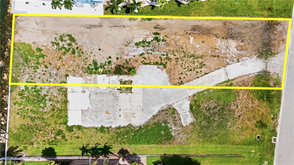 Cleared lot with existing concrete foundations and a partial driveway- Virtually Edited Image