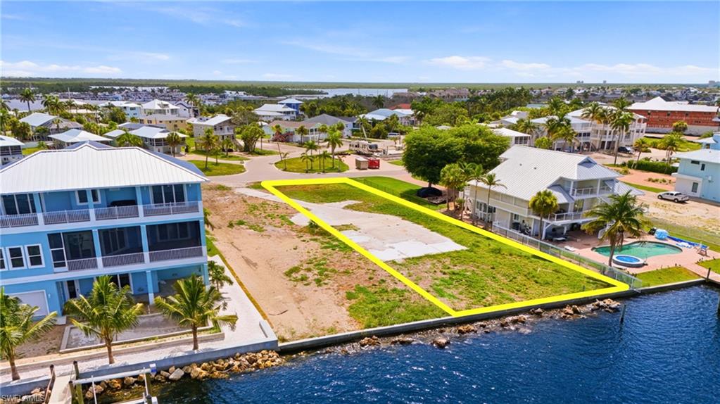 Waterfront land parcel featuring direct water frontage, a level building site, and surrounding residential properties - Virtually Edited Image