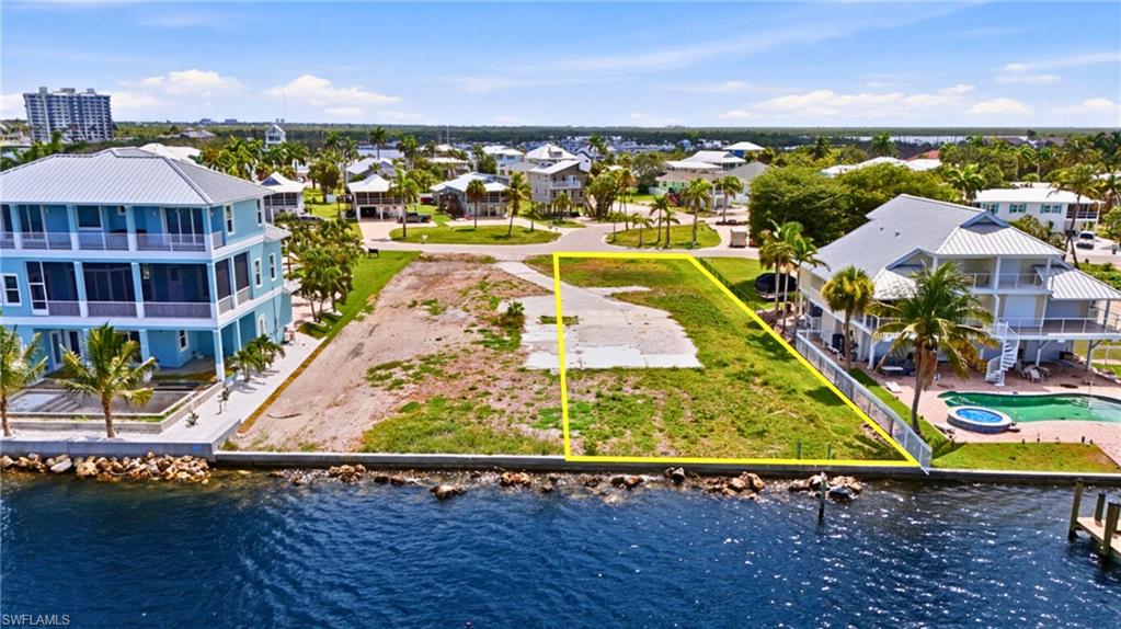 Waterfront parcel featuring a clear building site, direct canal access, and a rock revetment shoreline - Virtually Edited Image