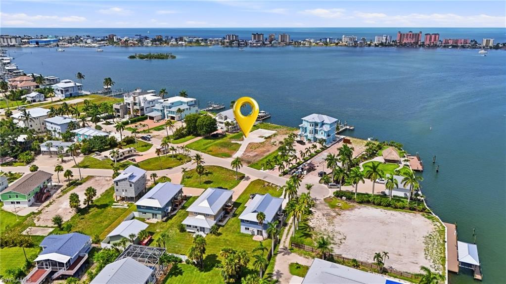 Waterfront parcel featuring a clear building site, mature palm trees, existing seawall, and access to a broad bay - Virtually Edited Image
