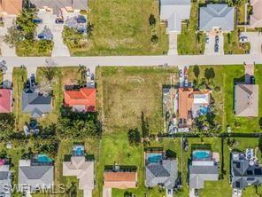 Aerial view of property and surrounding area featuring nearby suburban area