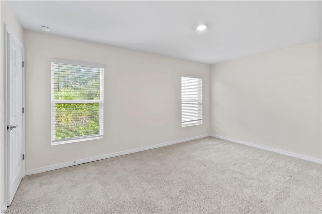 Empty room featuring light carpet and baseboards