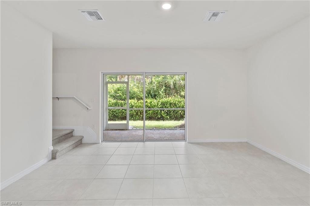 Unfurnished room featuring light tile patterned floors, stairway, and recessed lighting