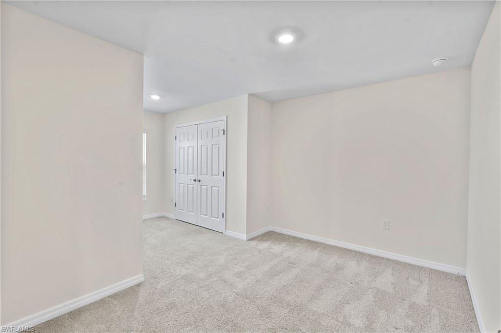 Spare room featuring light colored carpet and recessed lighting