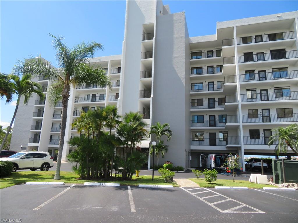 View of apartment building / complex with uncovered parking