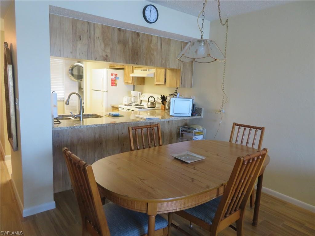 Dining area featuring dark wood finished floors and a textured ceiling
