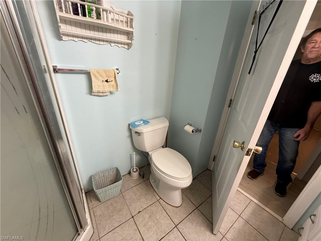 Full bathroom featuring toilet and light tile patterned floors