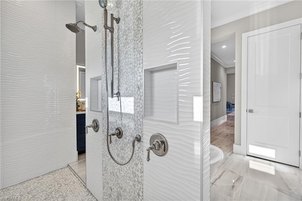 Bathroom view of a shower stall and ornamental molding