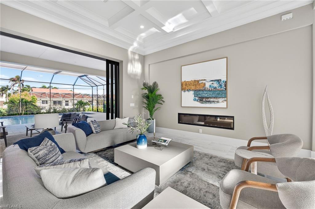 Living area with a sunroom, coffered ceiling, crown molding, beamed ceiling, and wood finished floors
