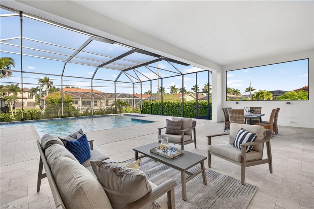 Outdoor pool featuring a sunroom, a patio, an outdoor hangout area, and glass enclosure