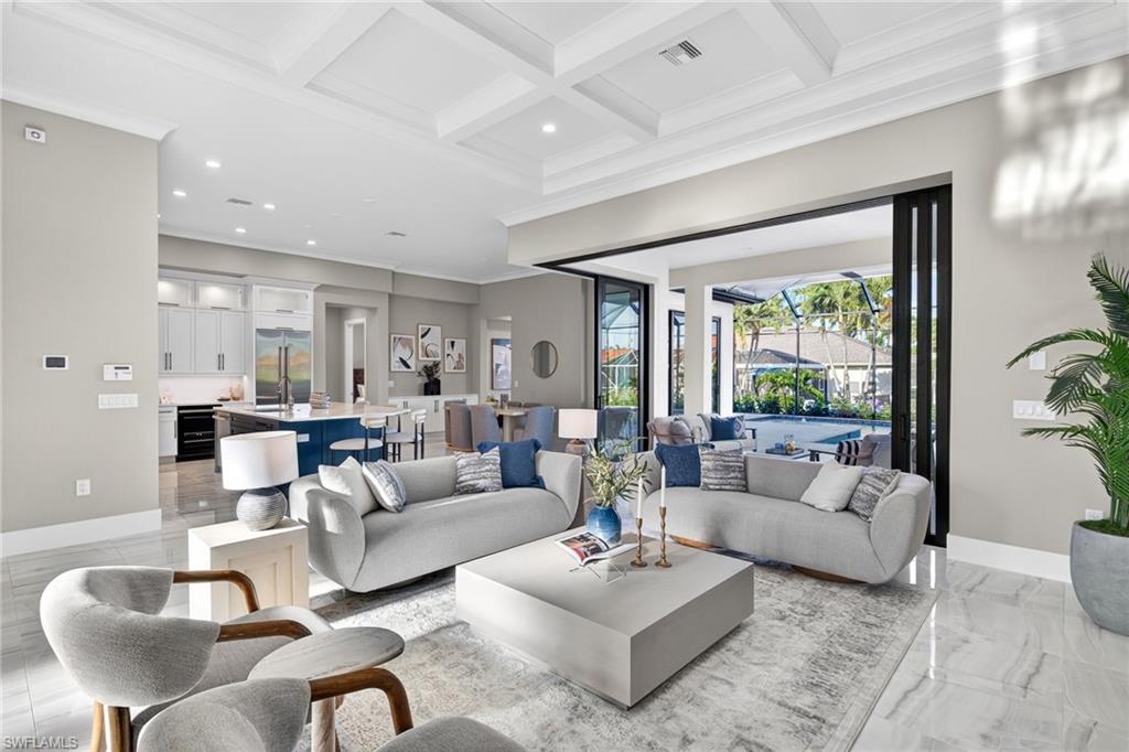 Living area featuring coffered ceiling, crown molding, healthy amount of natural light, beam ceiling, and recessed lighting