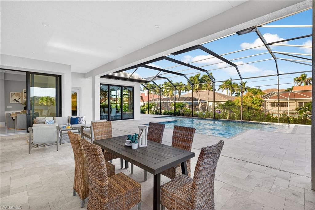 Outdoor pool with a patio area, a sunroom, glass enclosure, an outdoor hangout area, and outdoor dining area
