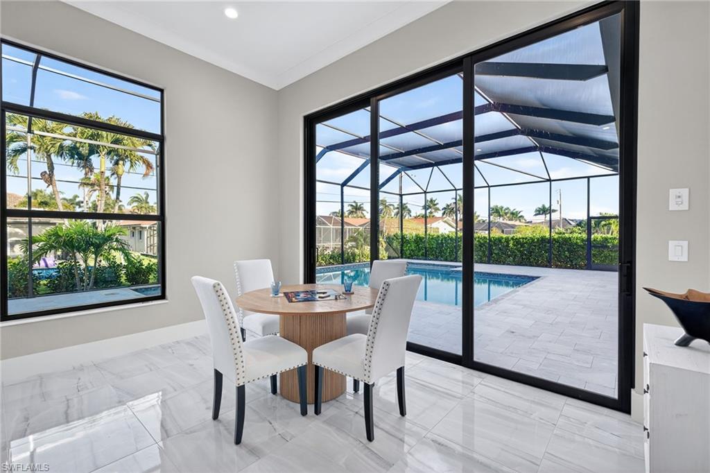 Dining space featuring a sunroom and light marble finish flooring
