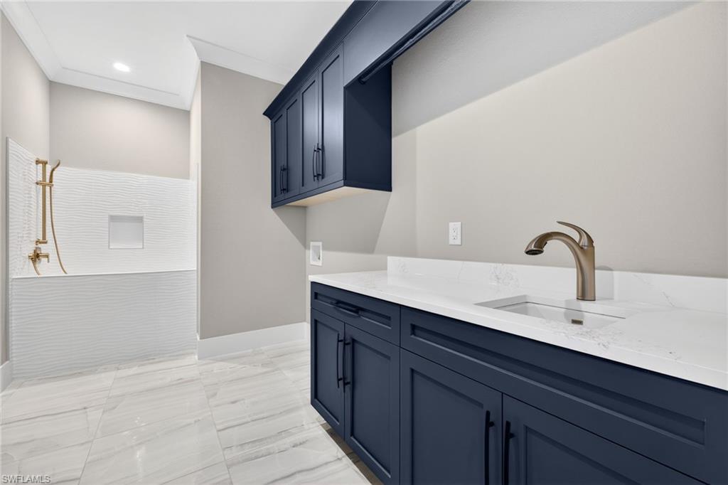 Laundry room with light marble finish floors, cabinet space, hookup for a washing machine, ornamental molding, and recessed lighting