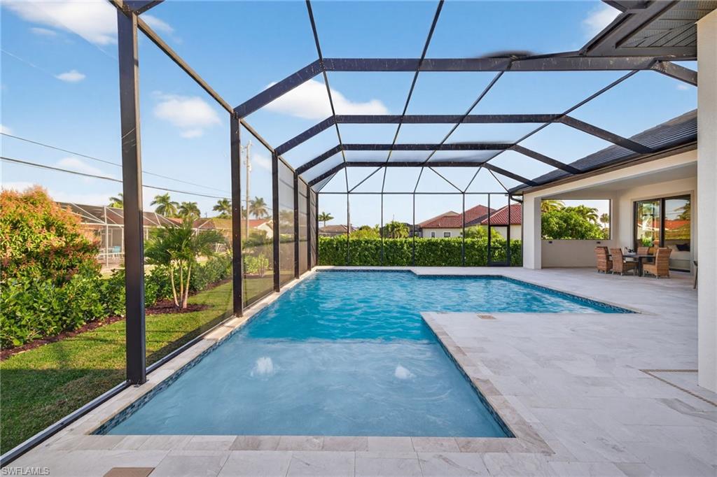 Outdoor pool with a sunroom, a patio, and glass enclosure