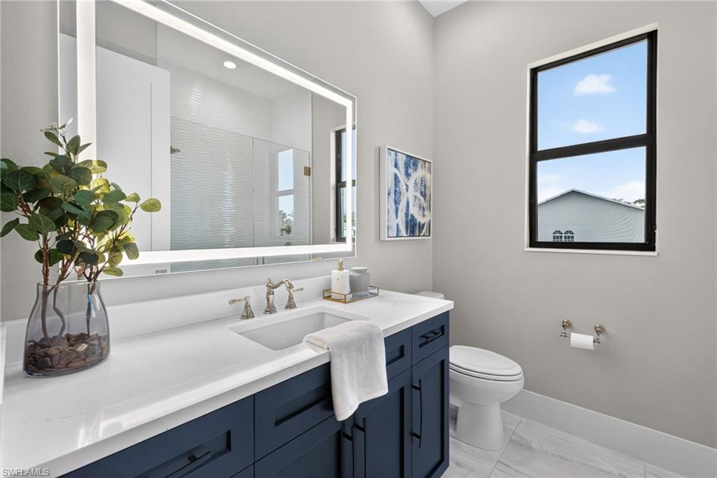 Full bath with a shower stall, vanity, and light marble finish floors