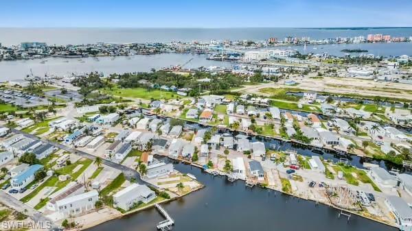 Aerial view of property and surrounding area with a large body of water and nearby suburban area