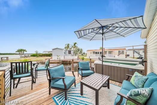Wooden deck with a hot tub and an outdoor hangout area