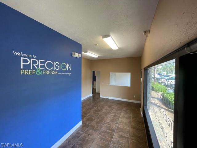 Unfurnished room featuring a textured ceiling and dark tile patterned flooring