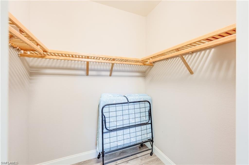 Walk in closet with wood finished floors