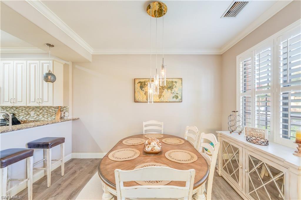 Dining area with crown molding and light wood-style floors