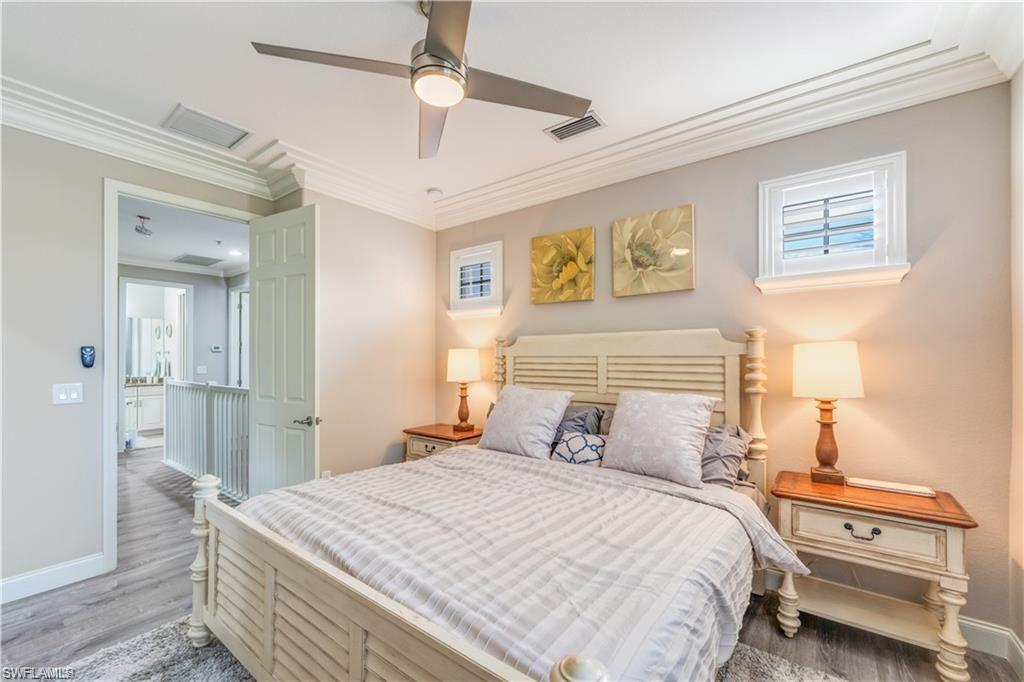 Bedroom with crown molding, wood finished floors, and ceiling fan