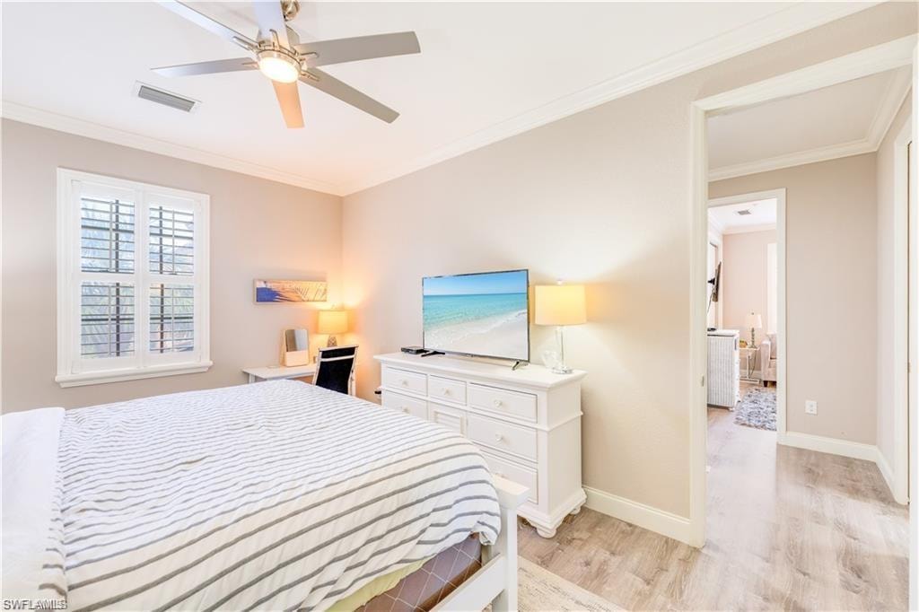 Bedroom featuring crown molding, light wood finished floors, and a ceiling fan
