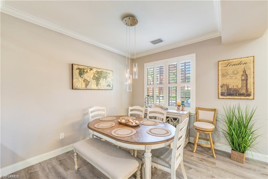 Dining space with ornamental molding and wood finished floors
