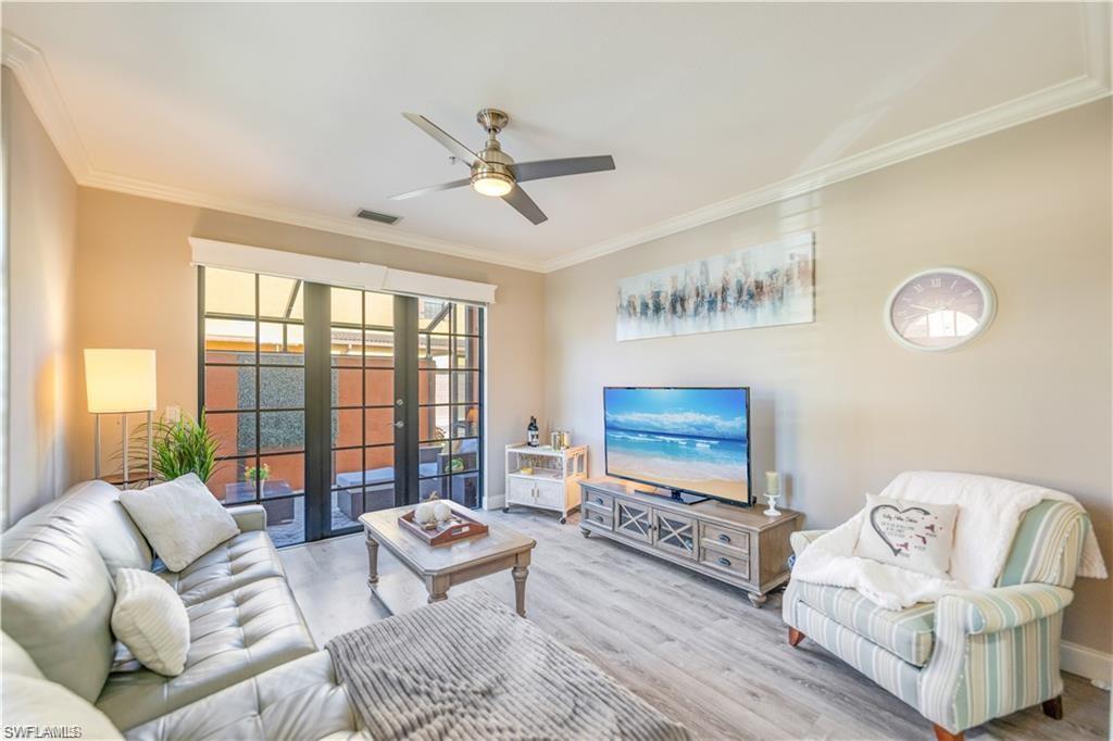 Living room featuring french doors, crown molding, wood finished floors, and ceiling fan