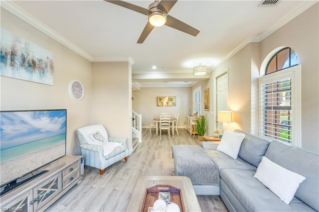 Living area with light wood-style flooring, crown molding, and a ceiling fan