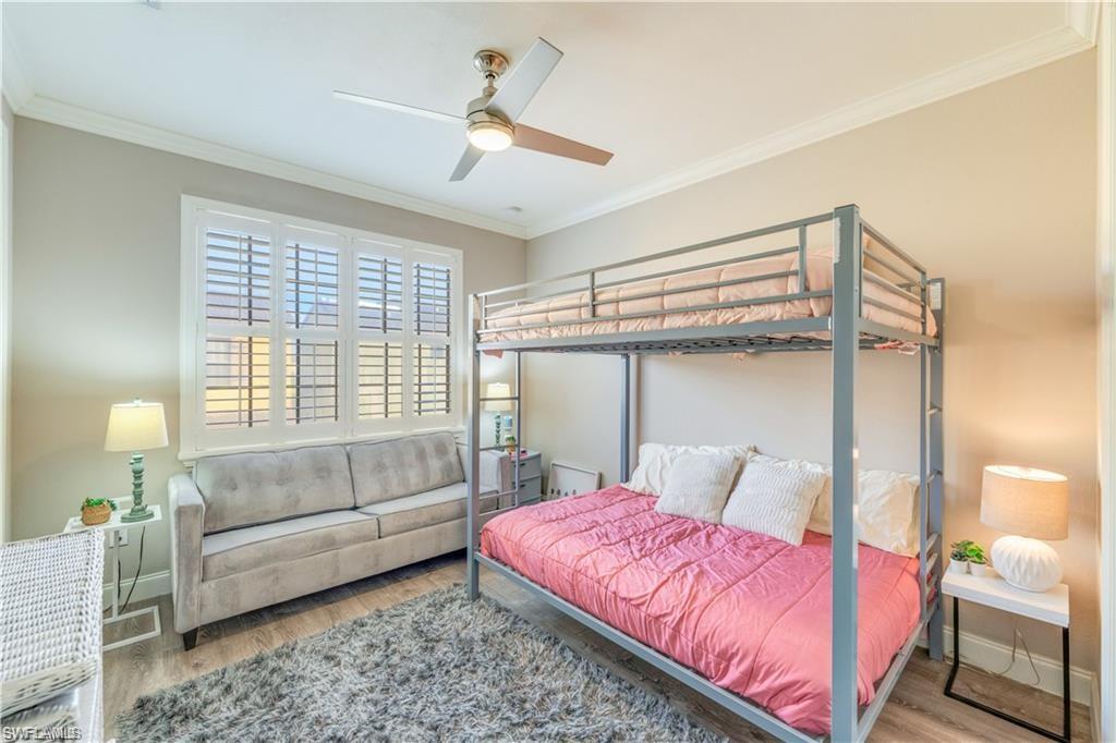Bedroom featuring crown molding, wood finished floors, and a ceiling fan