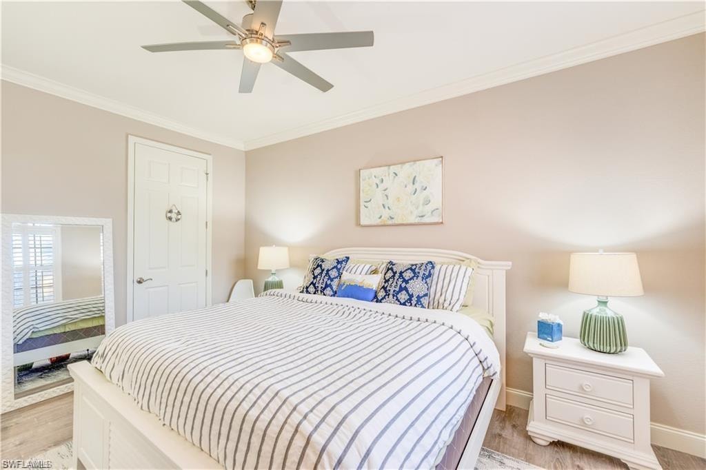 Bedroom with ornamental molding, light wood-type flooring, and a ceiling fan