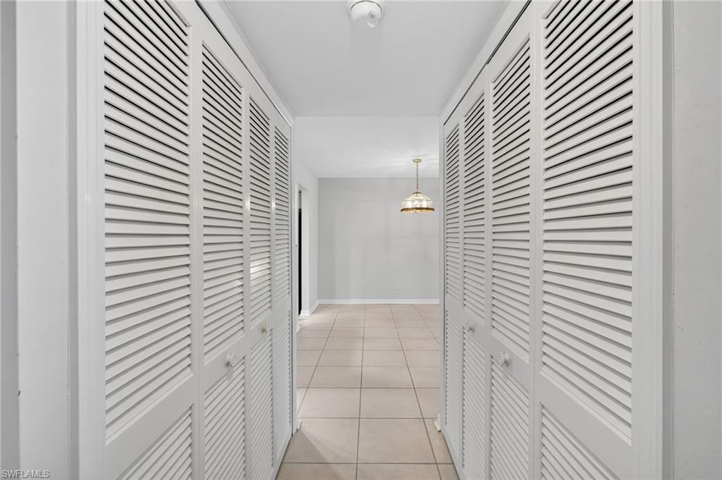 Hallway with light tile patterned flooring and baseboards