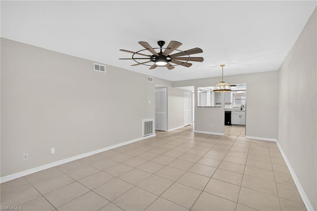 Unfurnished living room with light tile patterned floors and ceiling fan