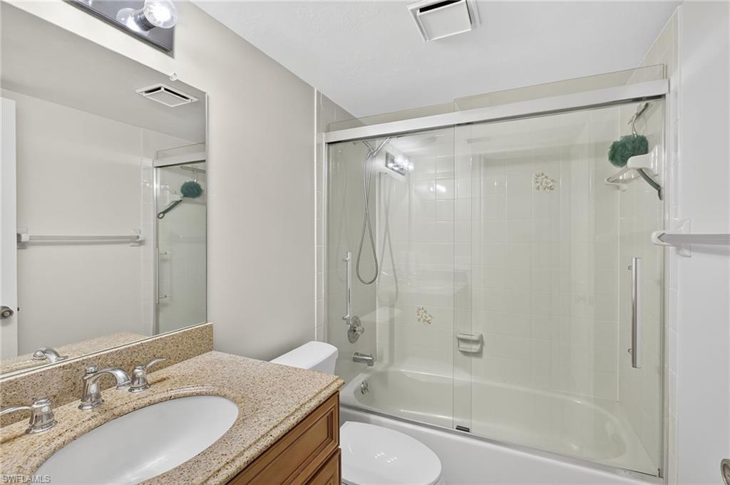 Bathroom featuring enclosed tub / shower combo and vanity