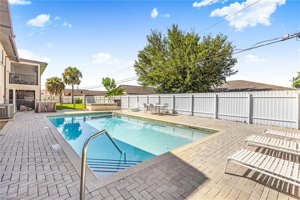 Community pool featuring a patio area, a fenced backyard, and a balcony