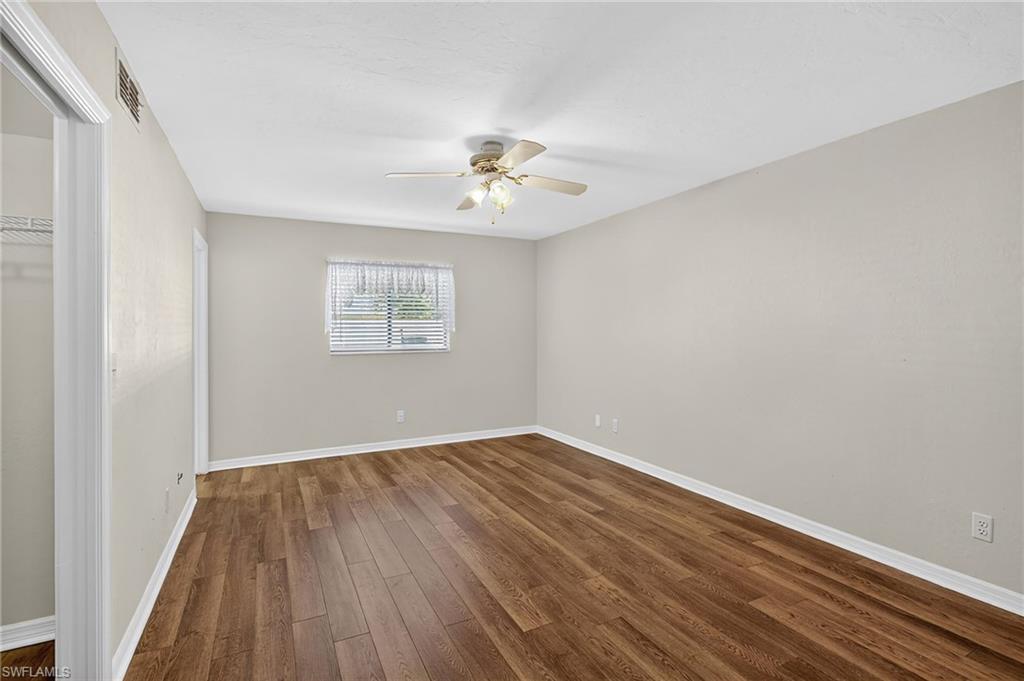 Unfurnished bedroom featuring dark wood-style floors, ceiling fan, and a closet