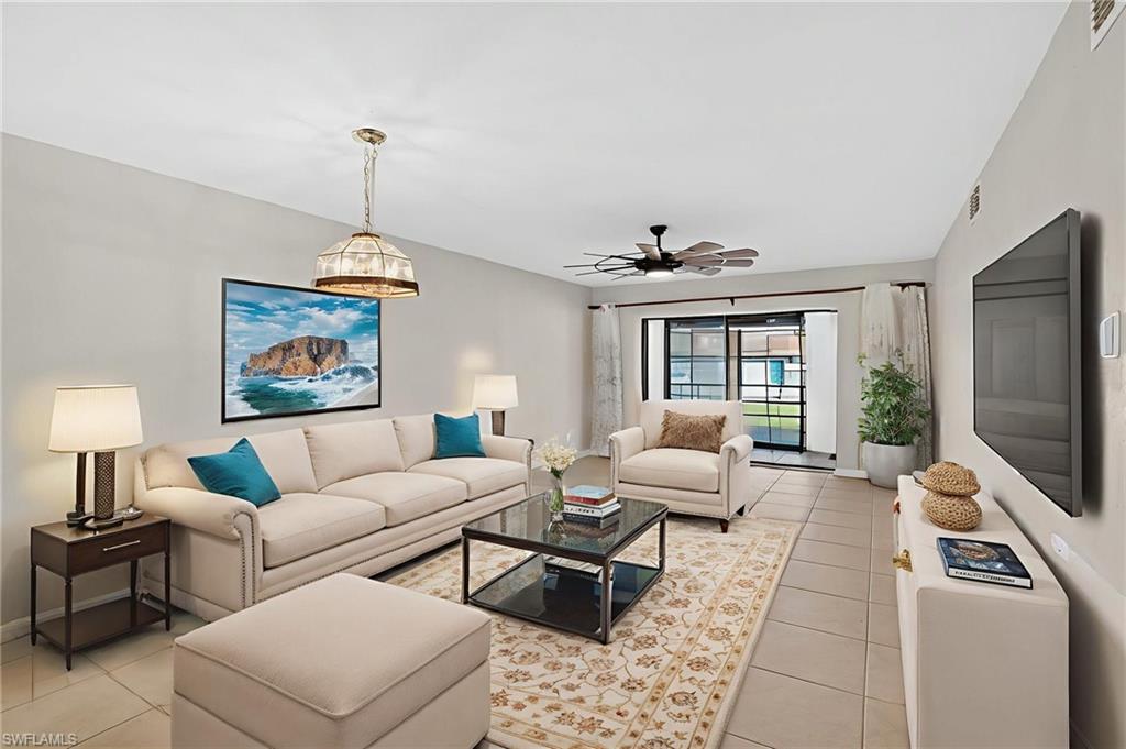 Living room featuring light tile patterned flooring and a ceiling fan
