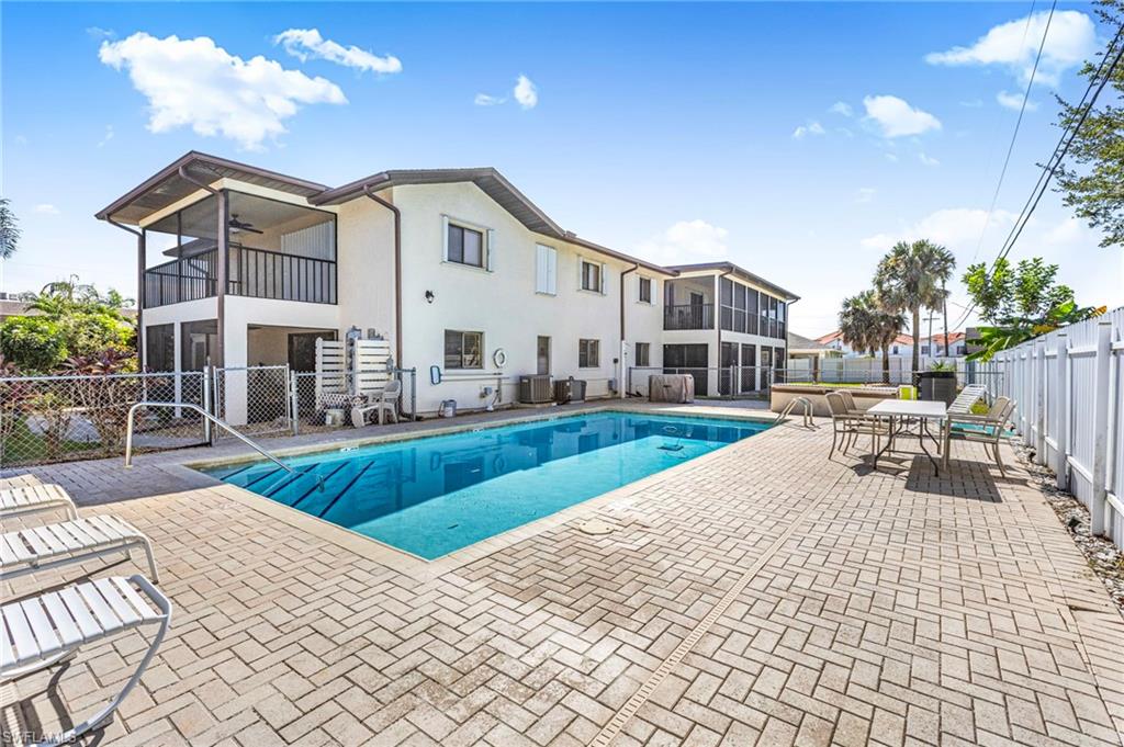 Community pool featuring a patio, a fenced backyard, a balcony, and a ceiling fan