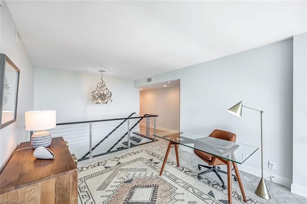 Home office featuring a chandelier and baseboards